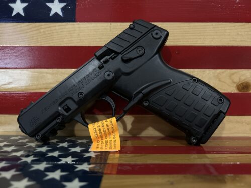 Black handgun resting on American flag background