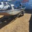 Fishing boat parked in front of sign-covered building.