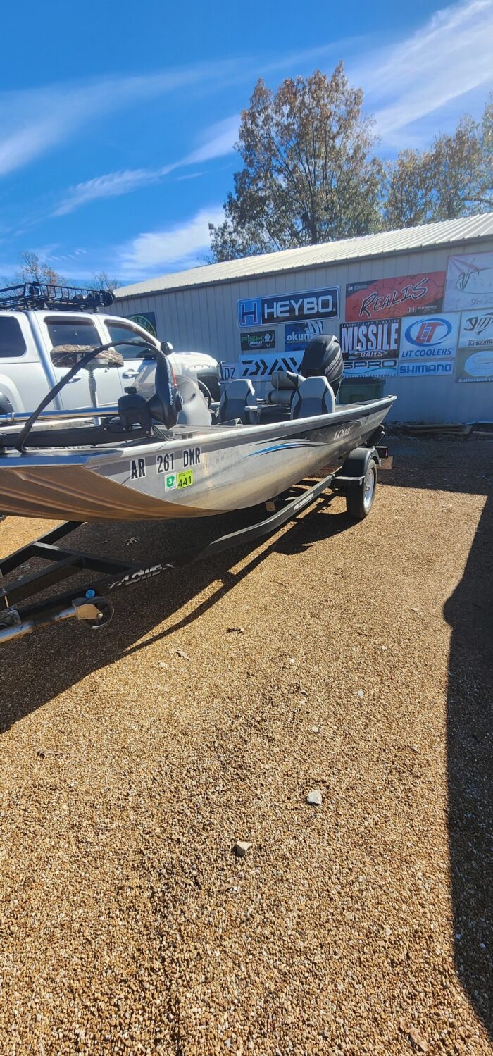 Fishing boat parked in front of sign-covered building.