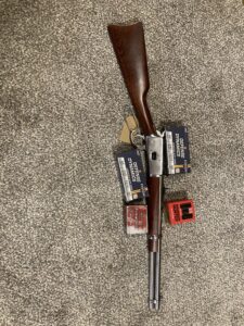 Lever-action rifle with ammunition on carpet