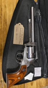 Silver revolver with wooden grip, labeled $550.