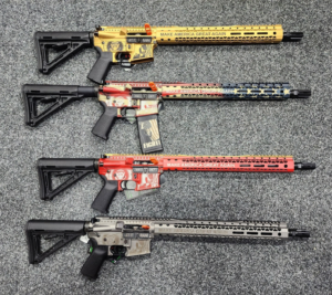 Four customized rifles on grey carpet.