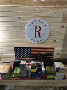 Rifle and ammo on wooden display with signs