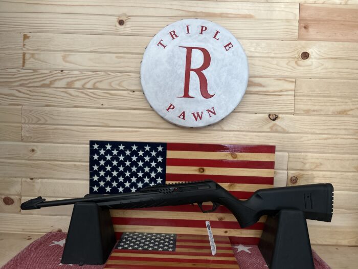 Black rifle on stand with American flags.