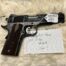 Springfield Armory 1911 pistol with handwritten label.