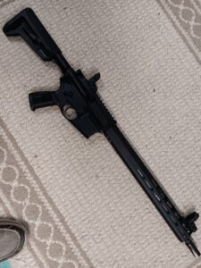 Black rifle on beige carpet