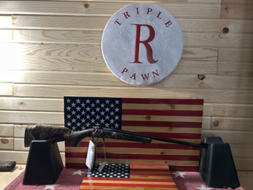 Rifle displayed on American flag backdrop in pawn shop.