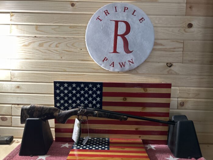 Rifle displayed on American flag backdrop in pawn shop.