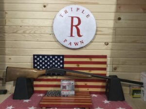 Rifle display with American flag background and logo