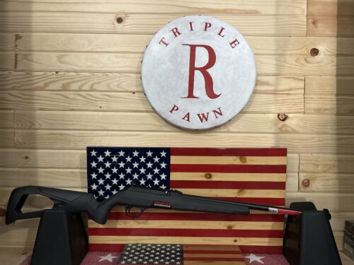 Rifle displayed with American flag backdrop.