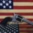 Revolver in front of American flag background.