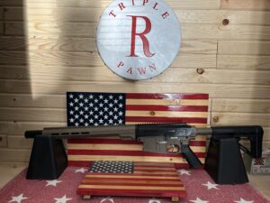 Rifle displayed with American flag backdrop.