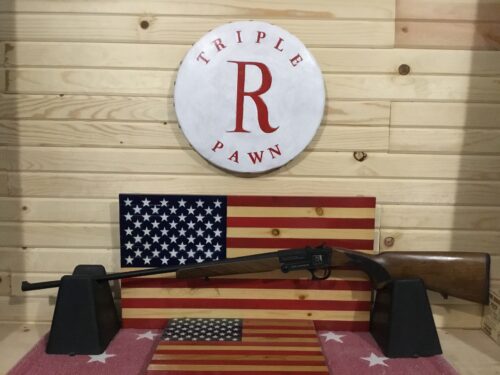 Rifle on American flag display, wooden background.