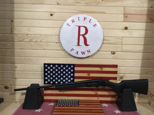 Shotgun displayed on American flag background in store.