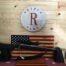 Rifle on display with American flag background.