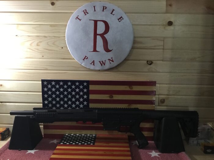 Shotgun displayed on American flag backdrop at shop.