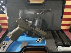 Pistol in case with accessories and American flag background.