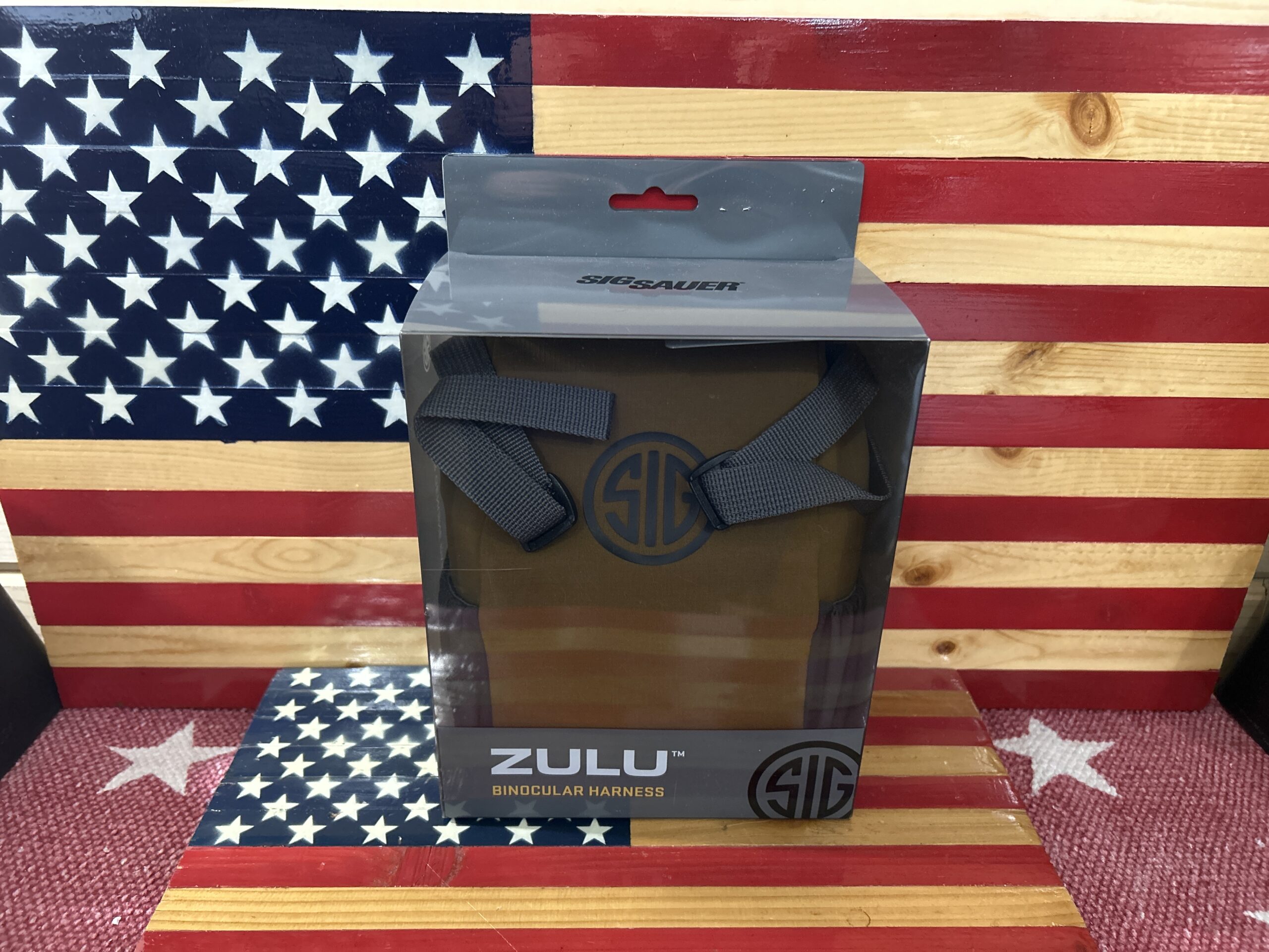 Zulu binocular harness packaging on American flag backdrop.