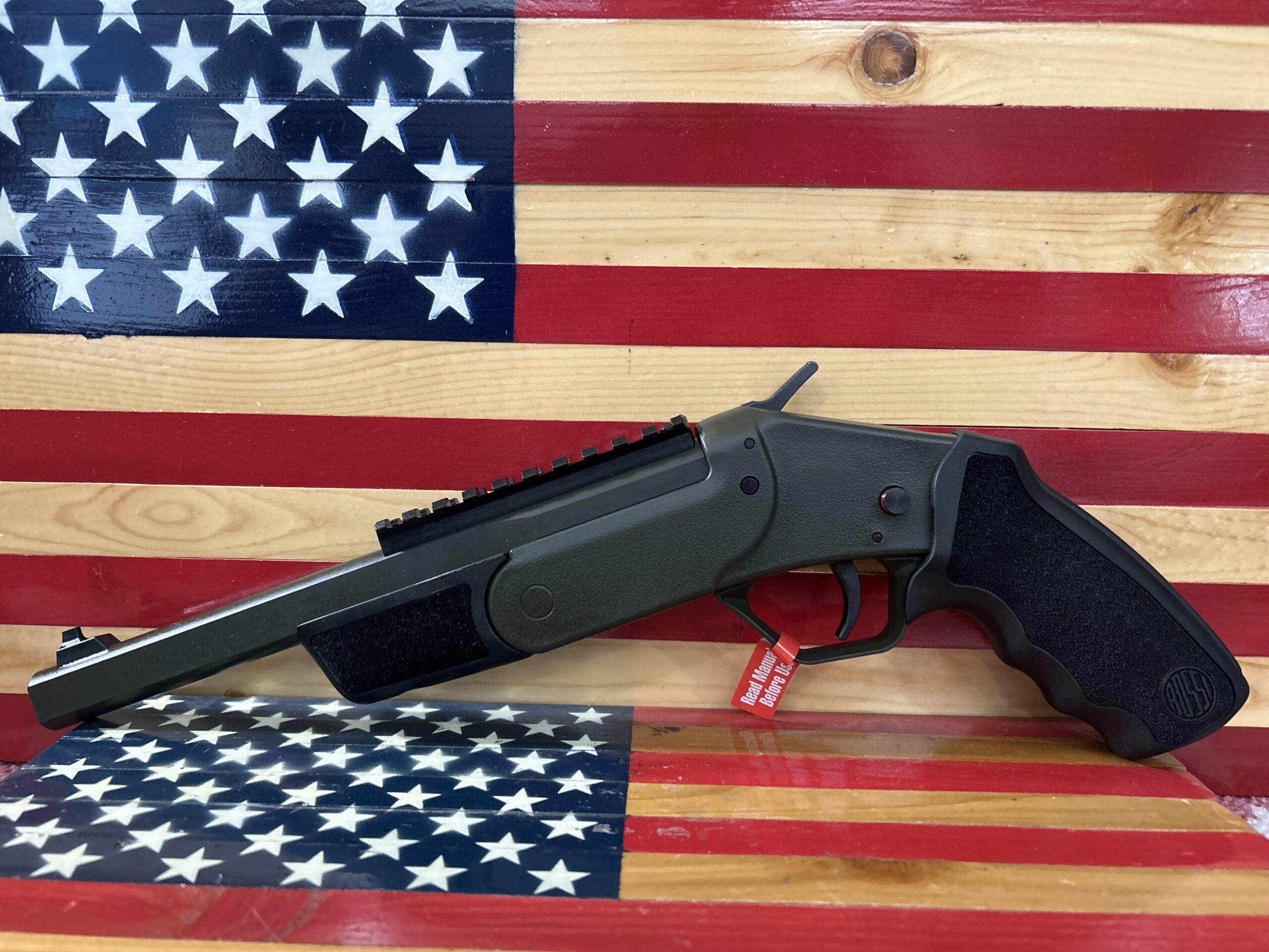 Handgun displayed in front of American flag.
