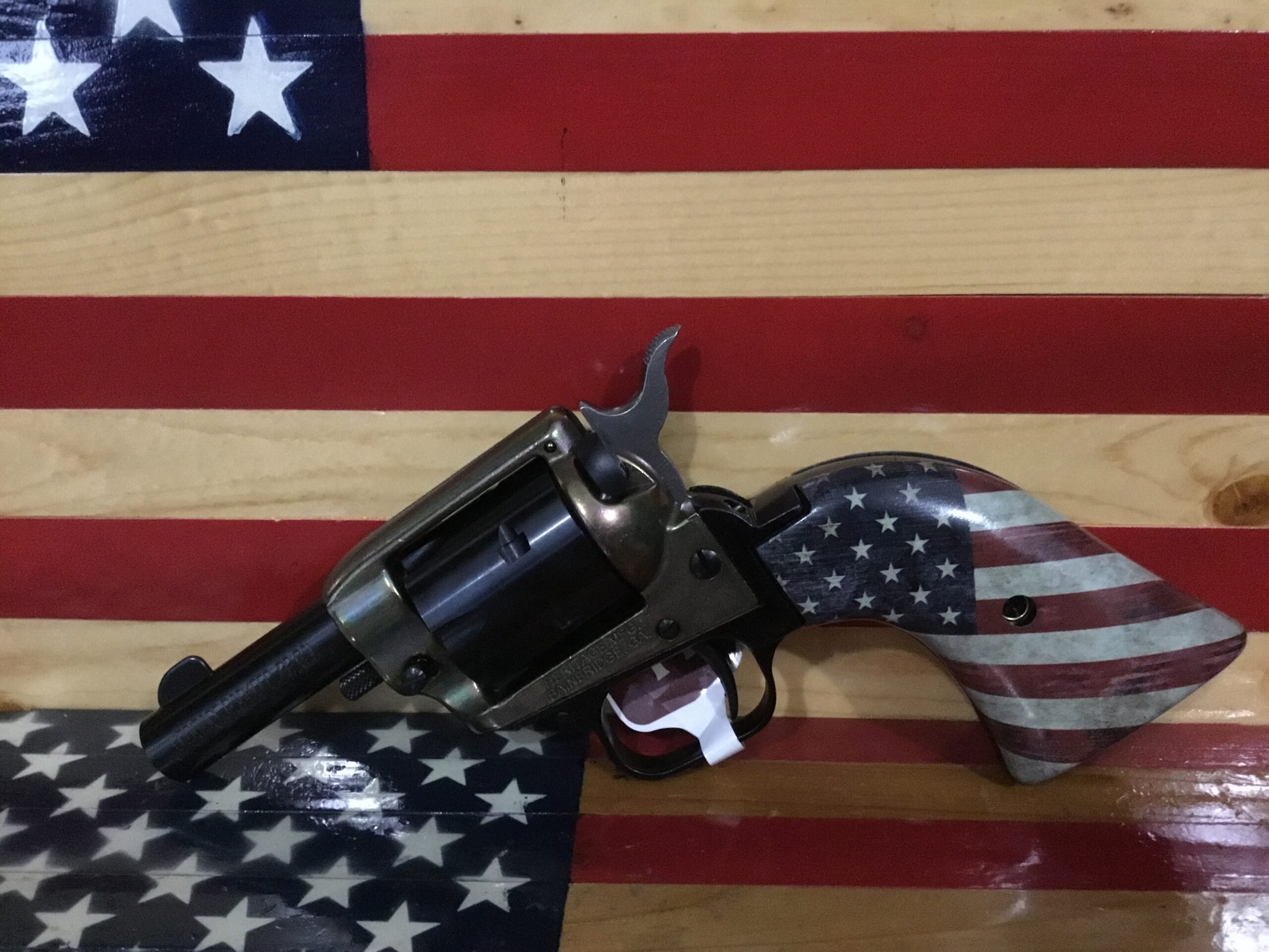 Revolver with American flag design on wooden background.