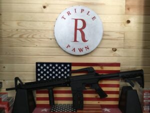 Rifle displayed against American flag backdrop.