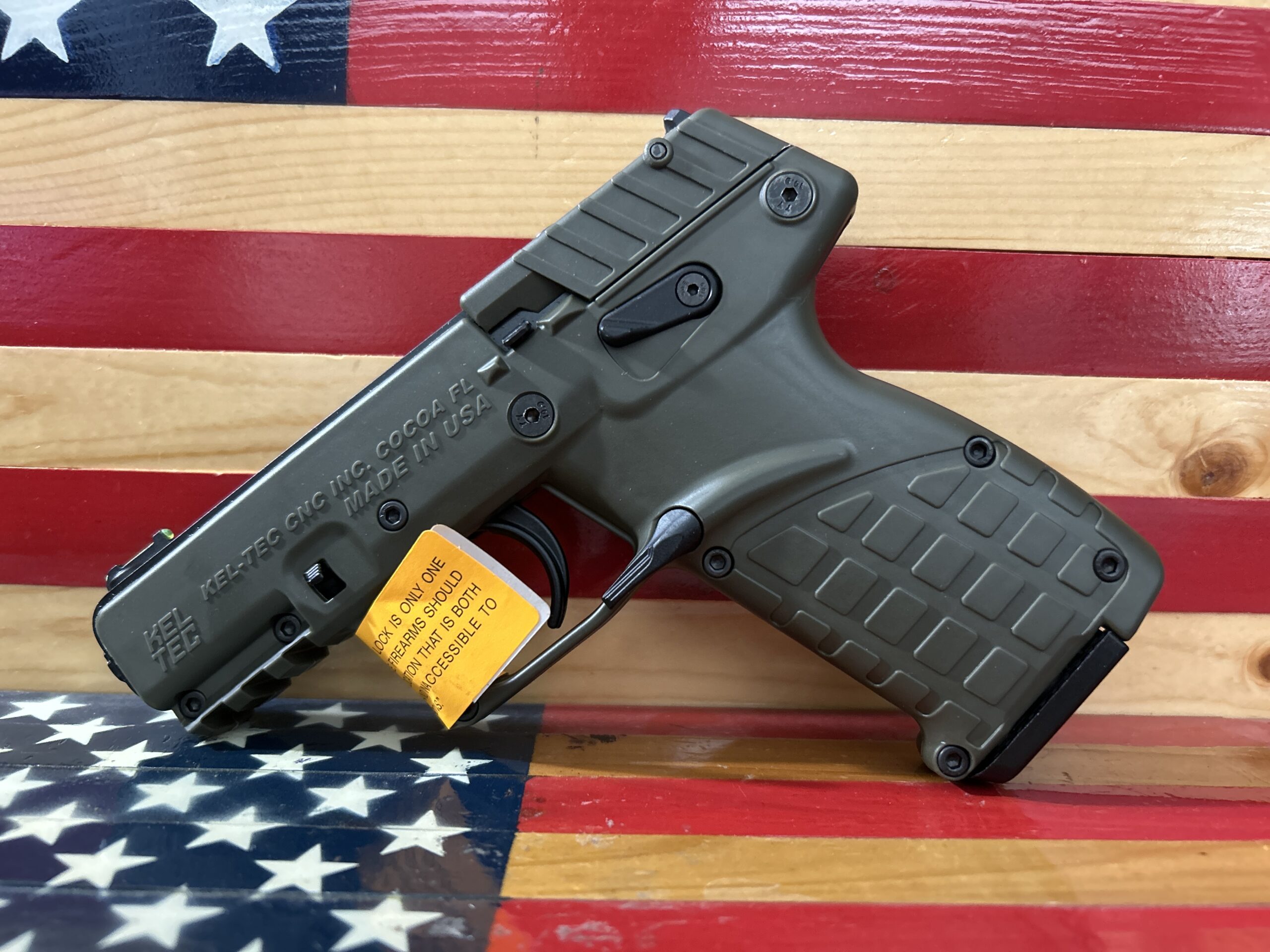 Handgun displayed on American flag background.