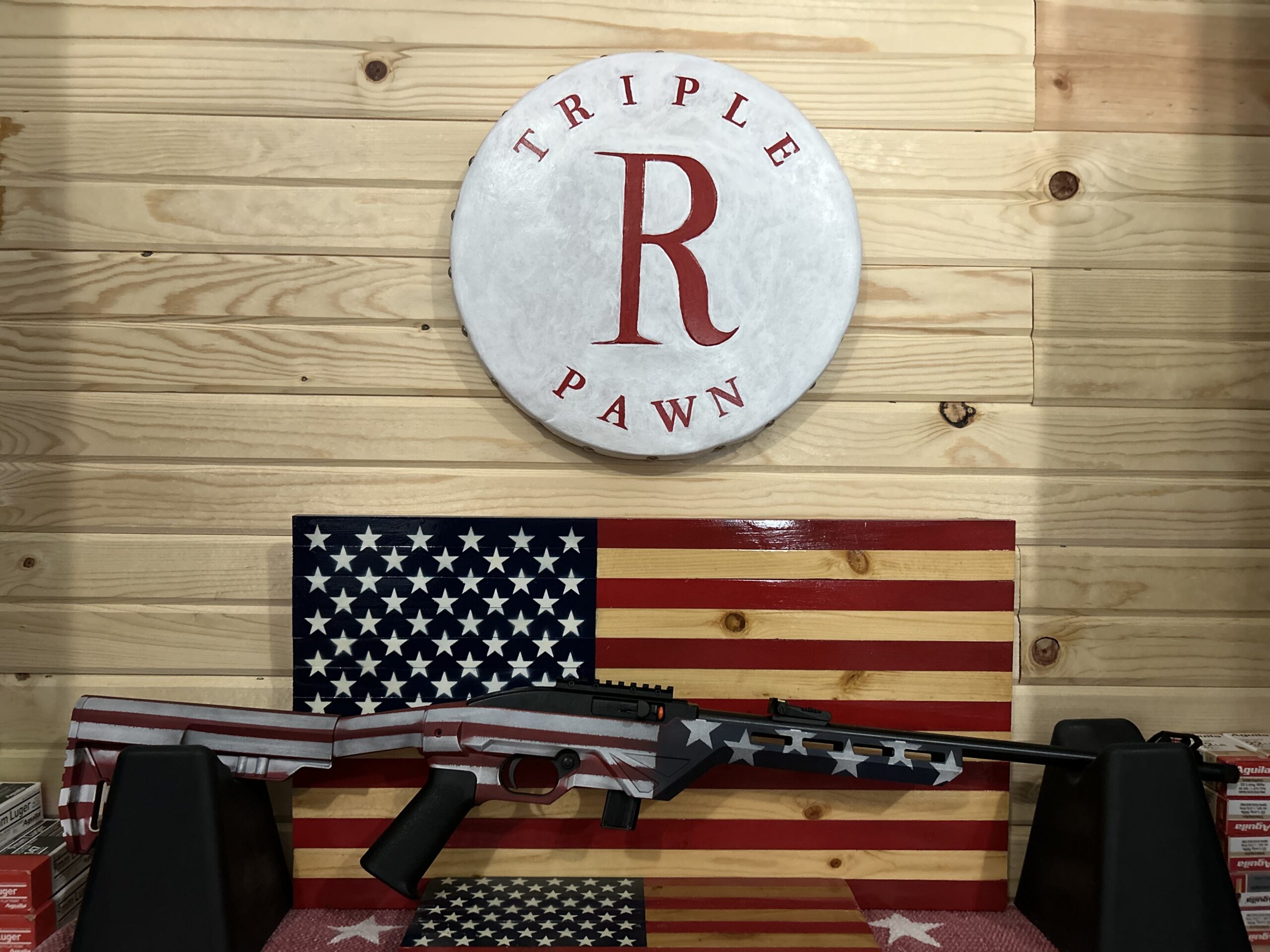 American flag-themed rifle in pawn shop display.