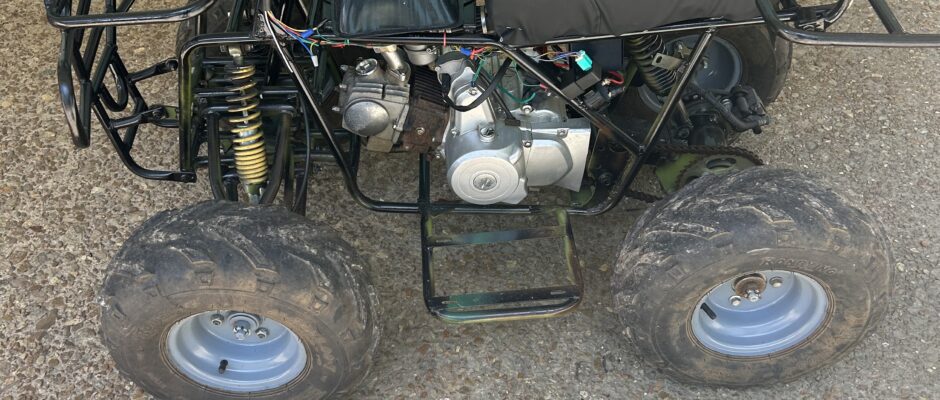 Four-wheeler parked on gravel surface.