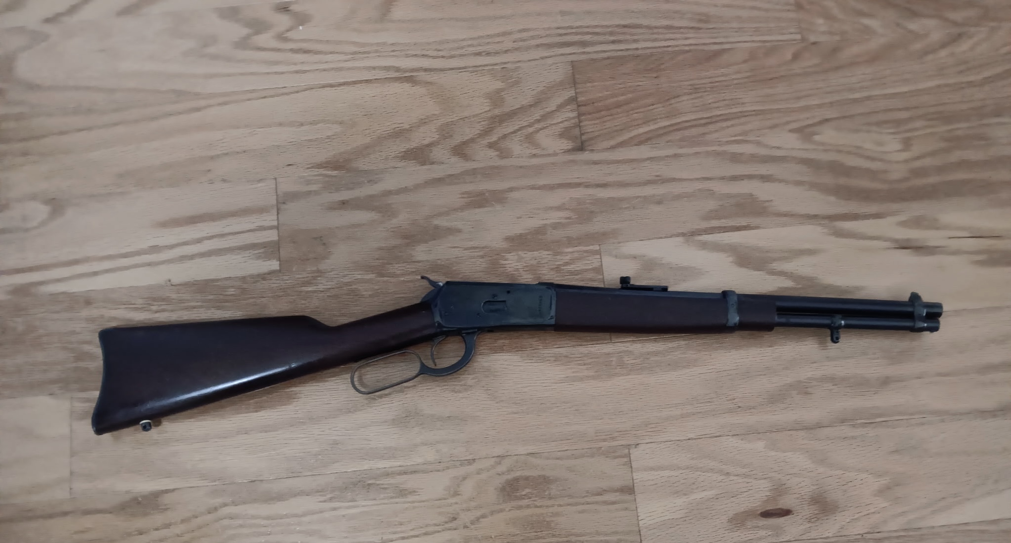 Lever-action rifle on wooden floor