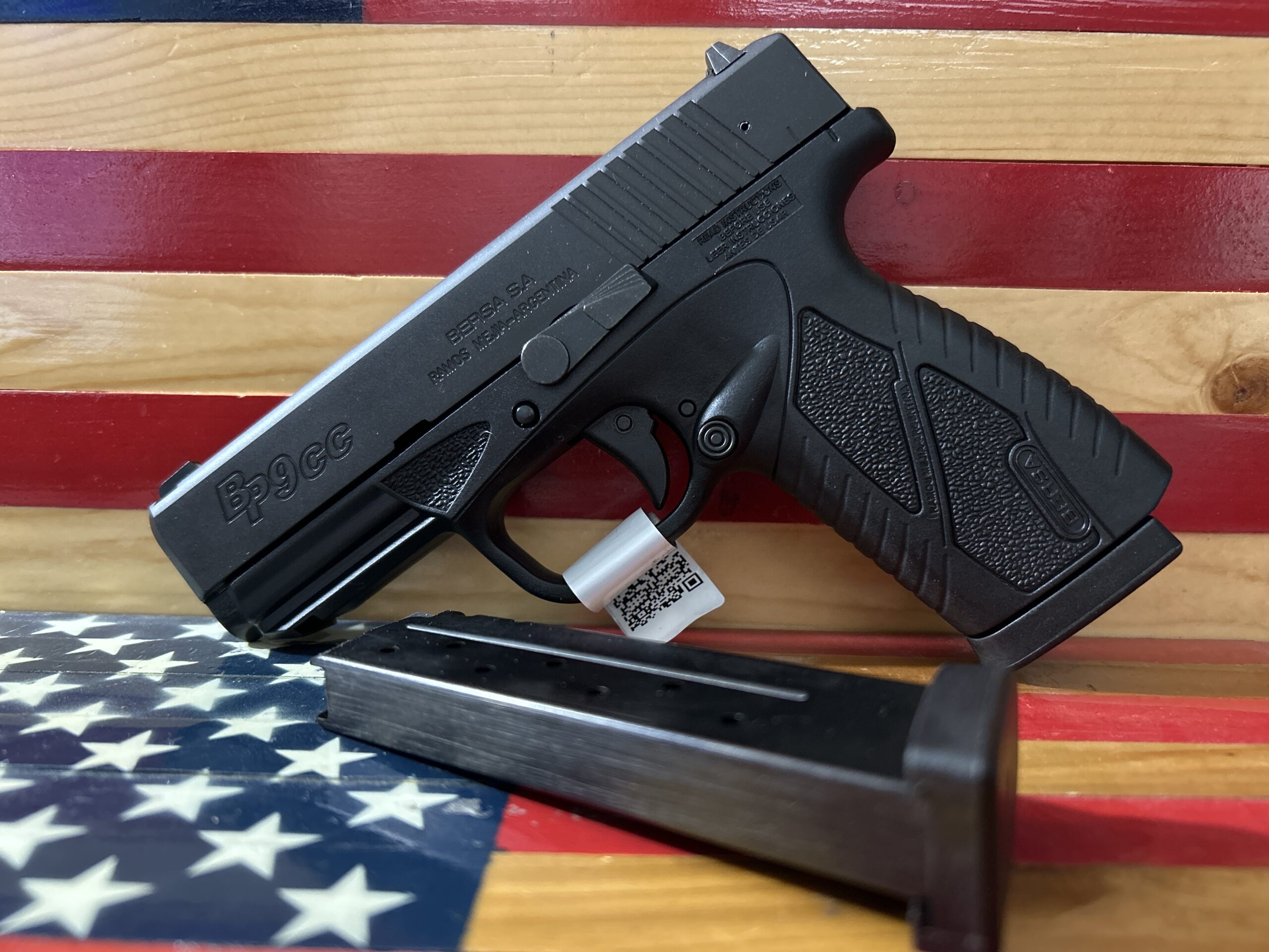 Handgun with magazine on American flag background.
