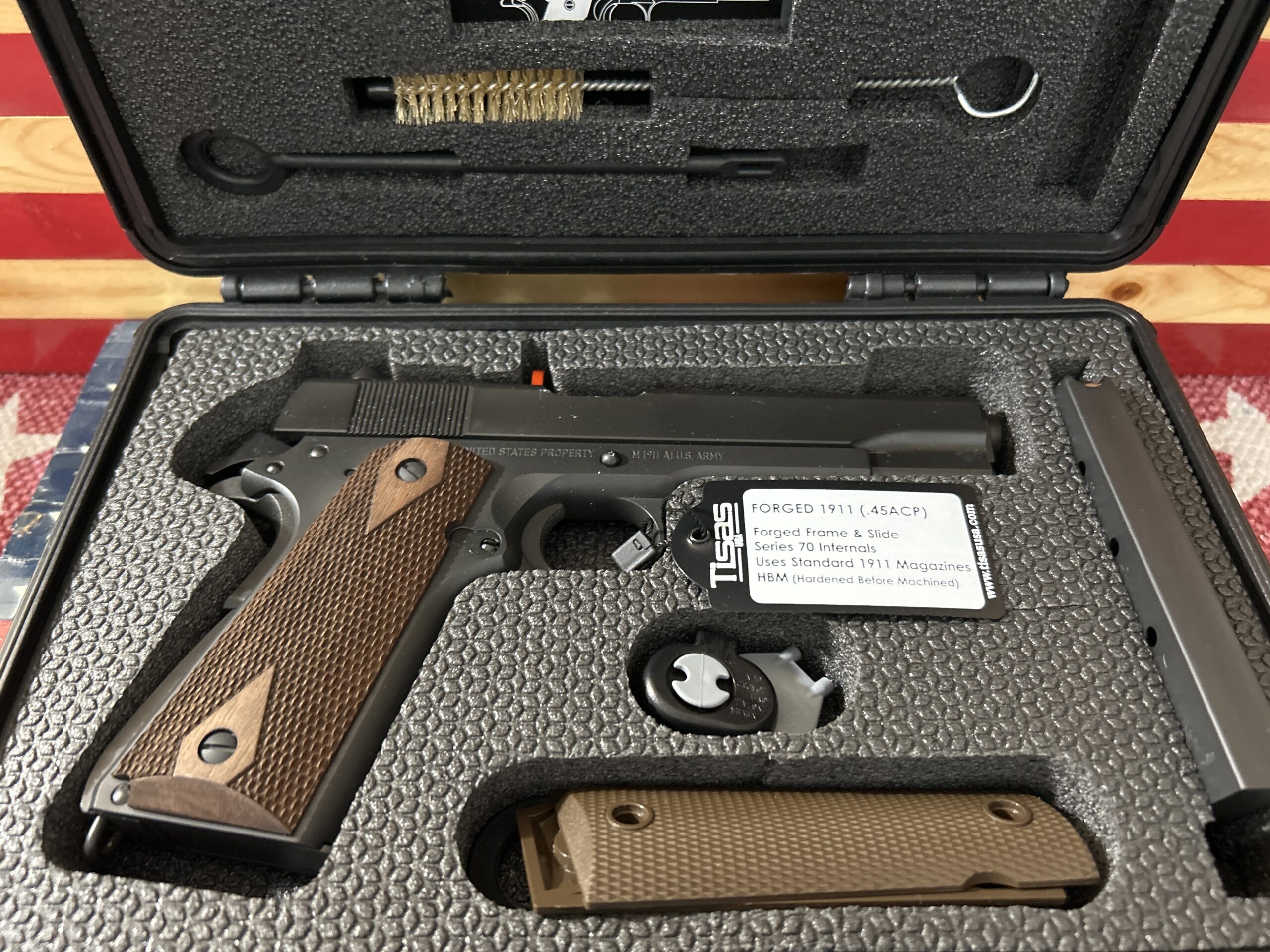 Forged 1911 pistol in protective case with accessories.