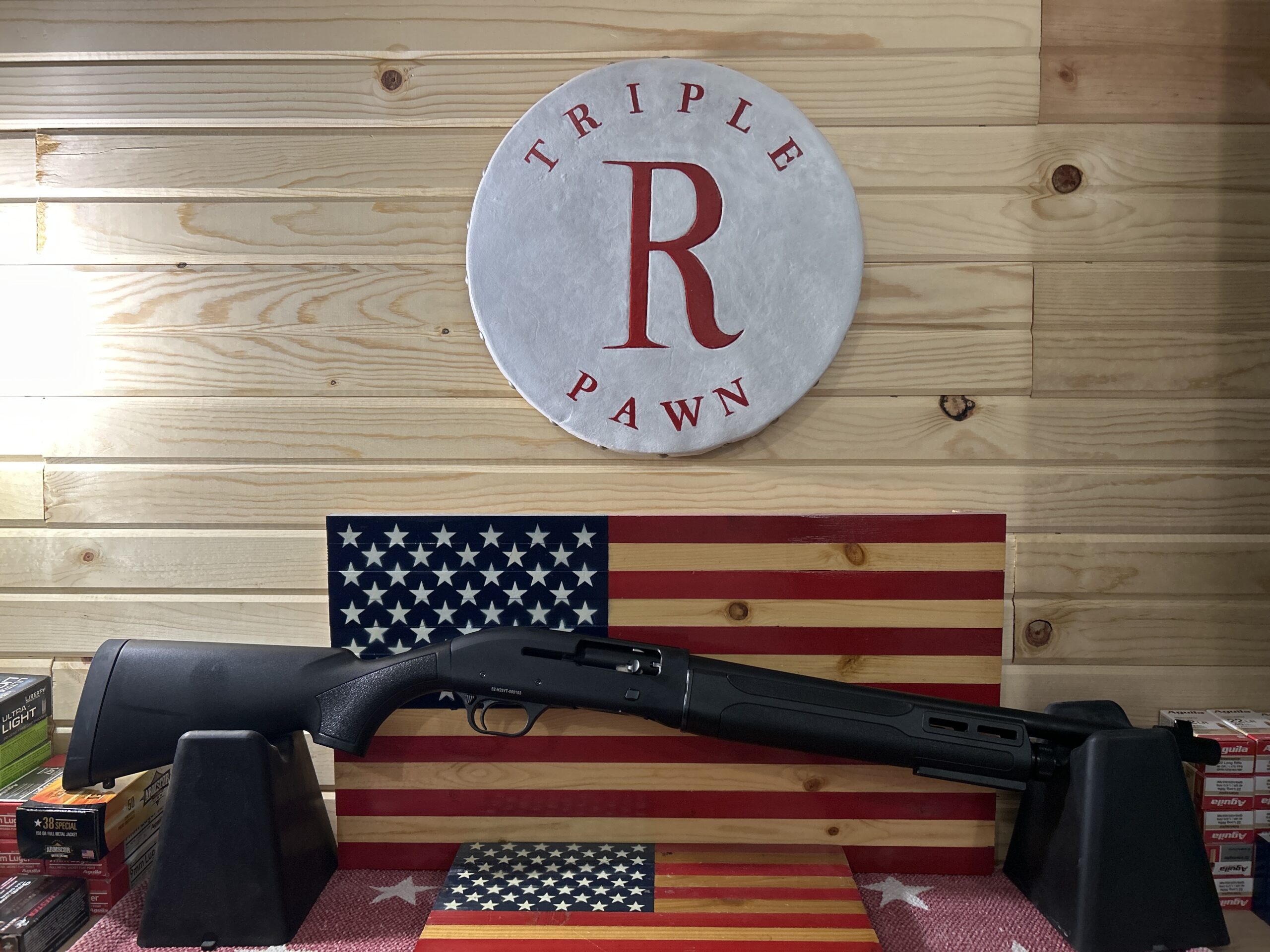 Shotgun displayed on stand with American flags