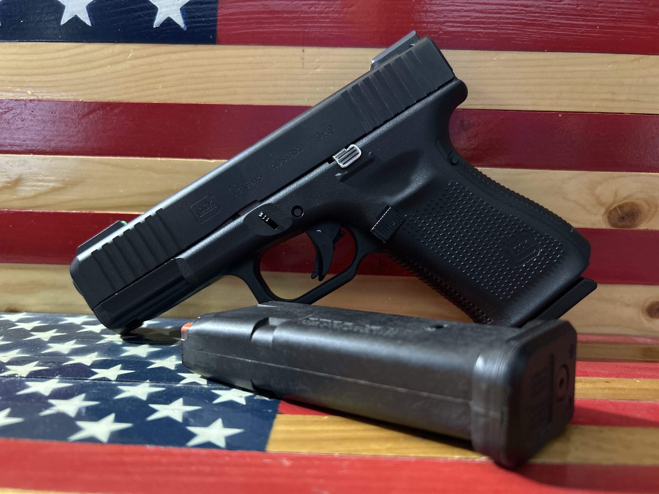 Handgun with magazine on American flag background.