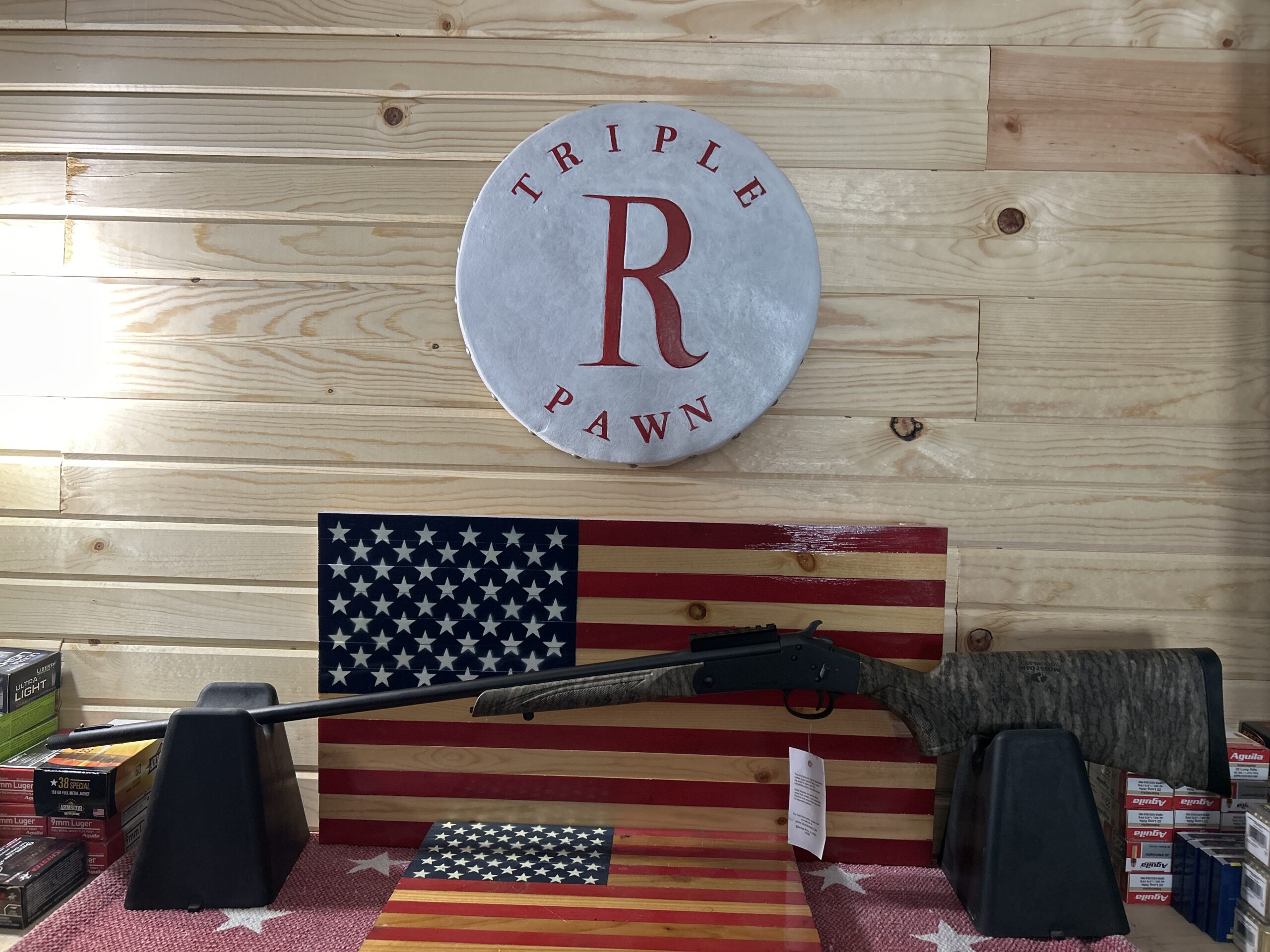 Hunting rifle displayed on American flag background.