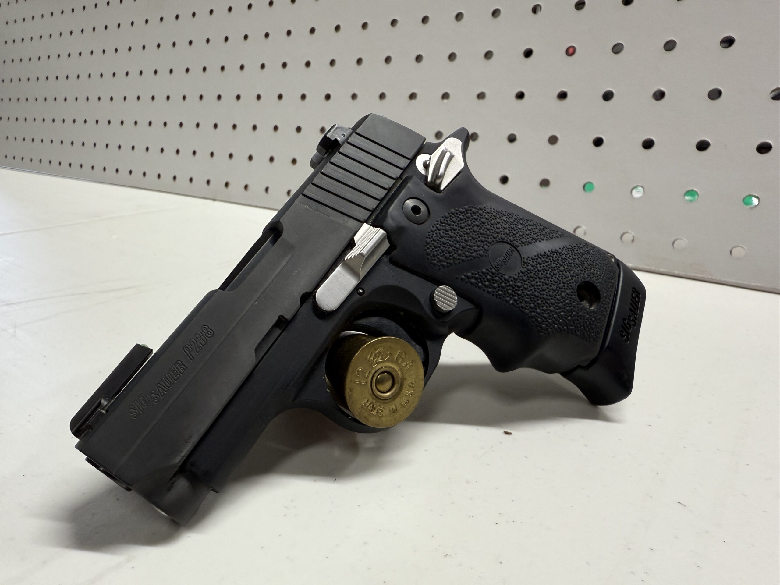 Black handgun with grip, displayed on white surface.