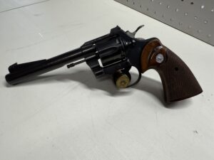 Black revolver with wooden grip on table.