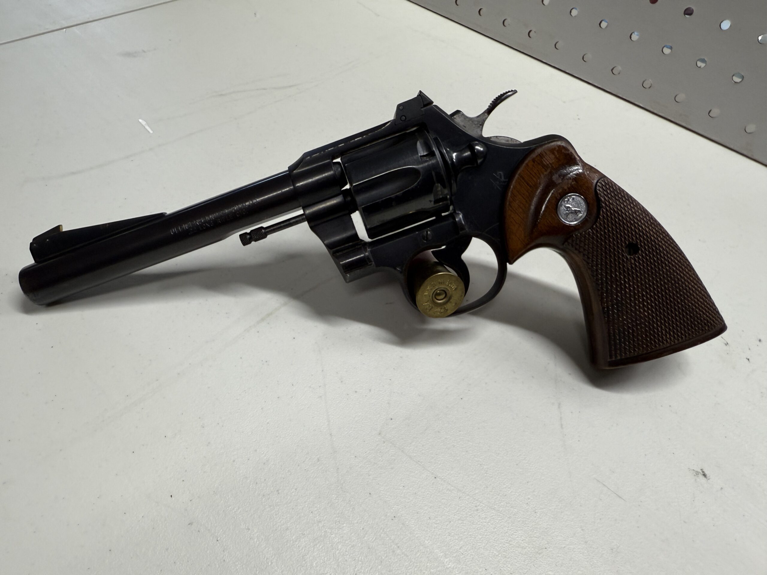 Black revolver with wooden grip on table.