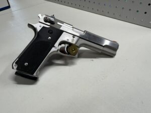 Silver handgun with black grip on table.