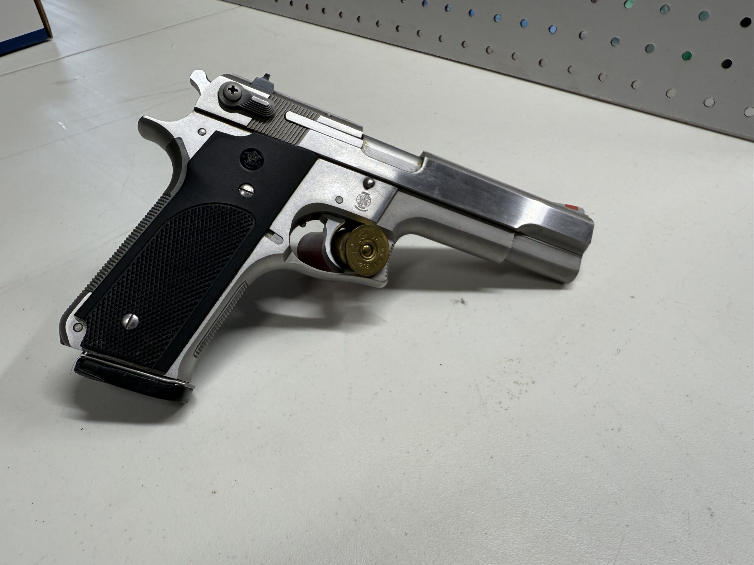 Silver handgun with black grip on table.