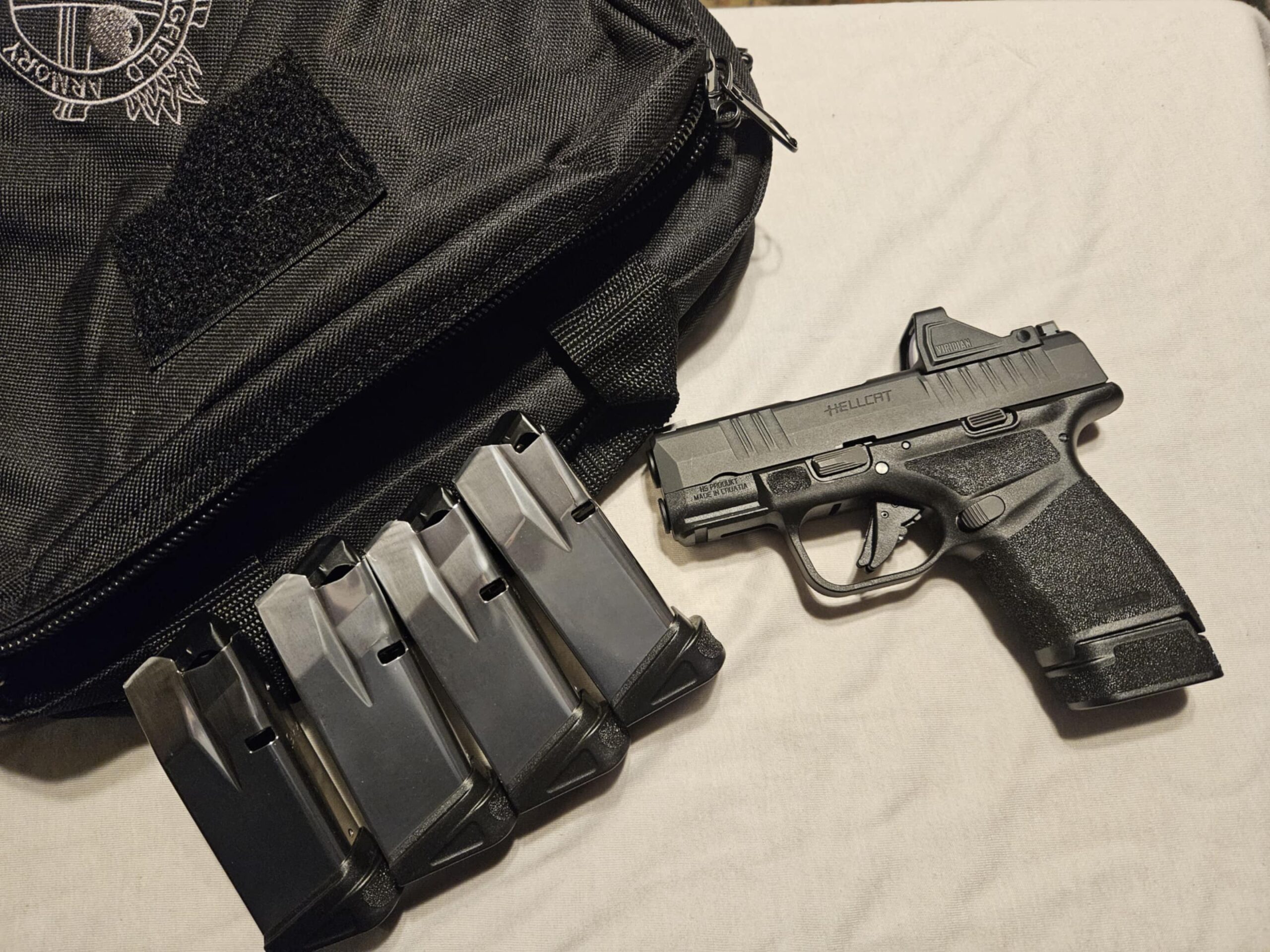 Pistol with magazines next to a bag.