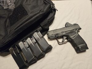 Black handgun with magazines on table.
