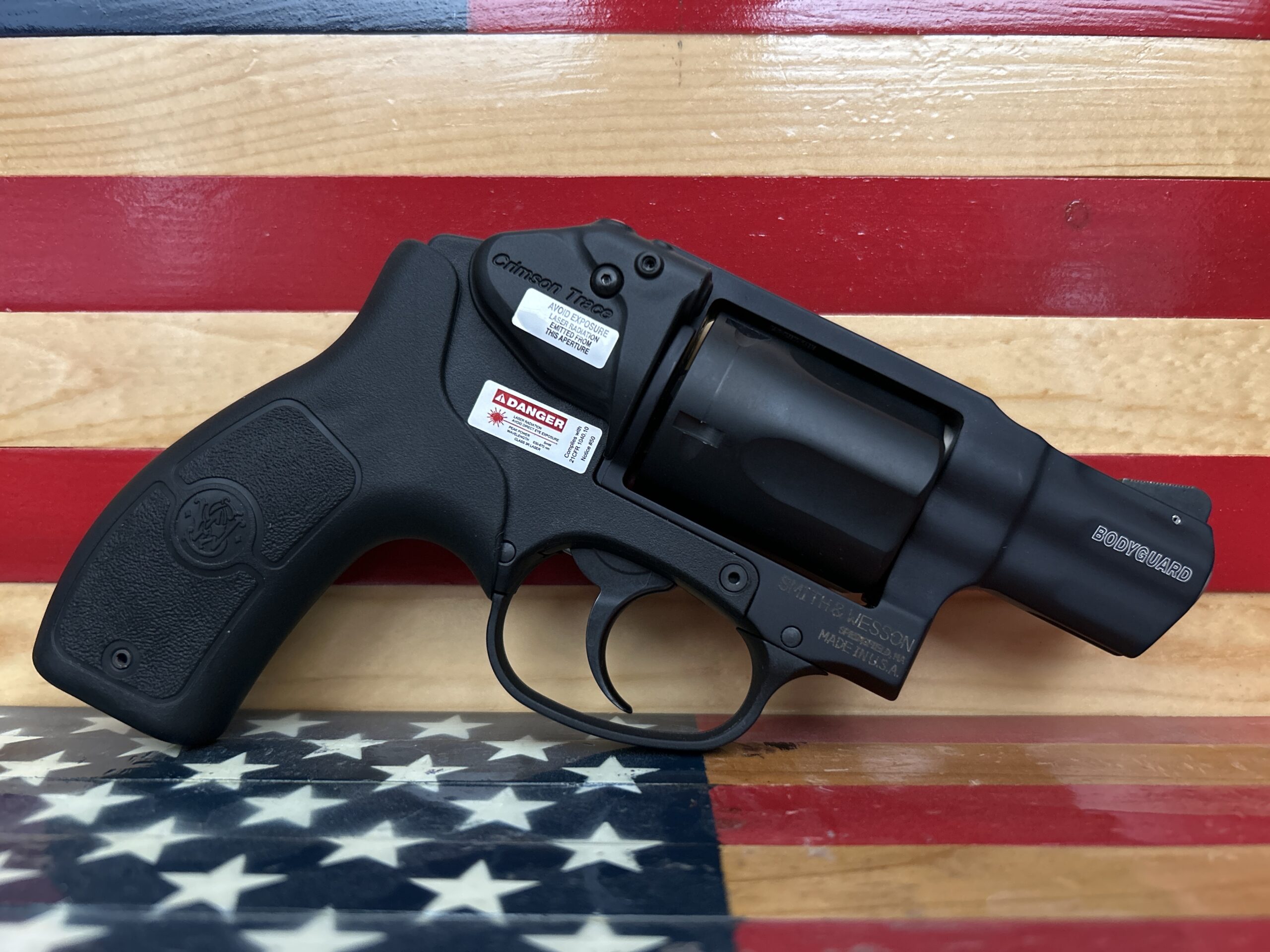 Black revolver against American flag background.