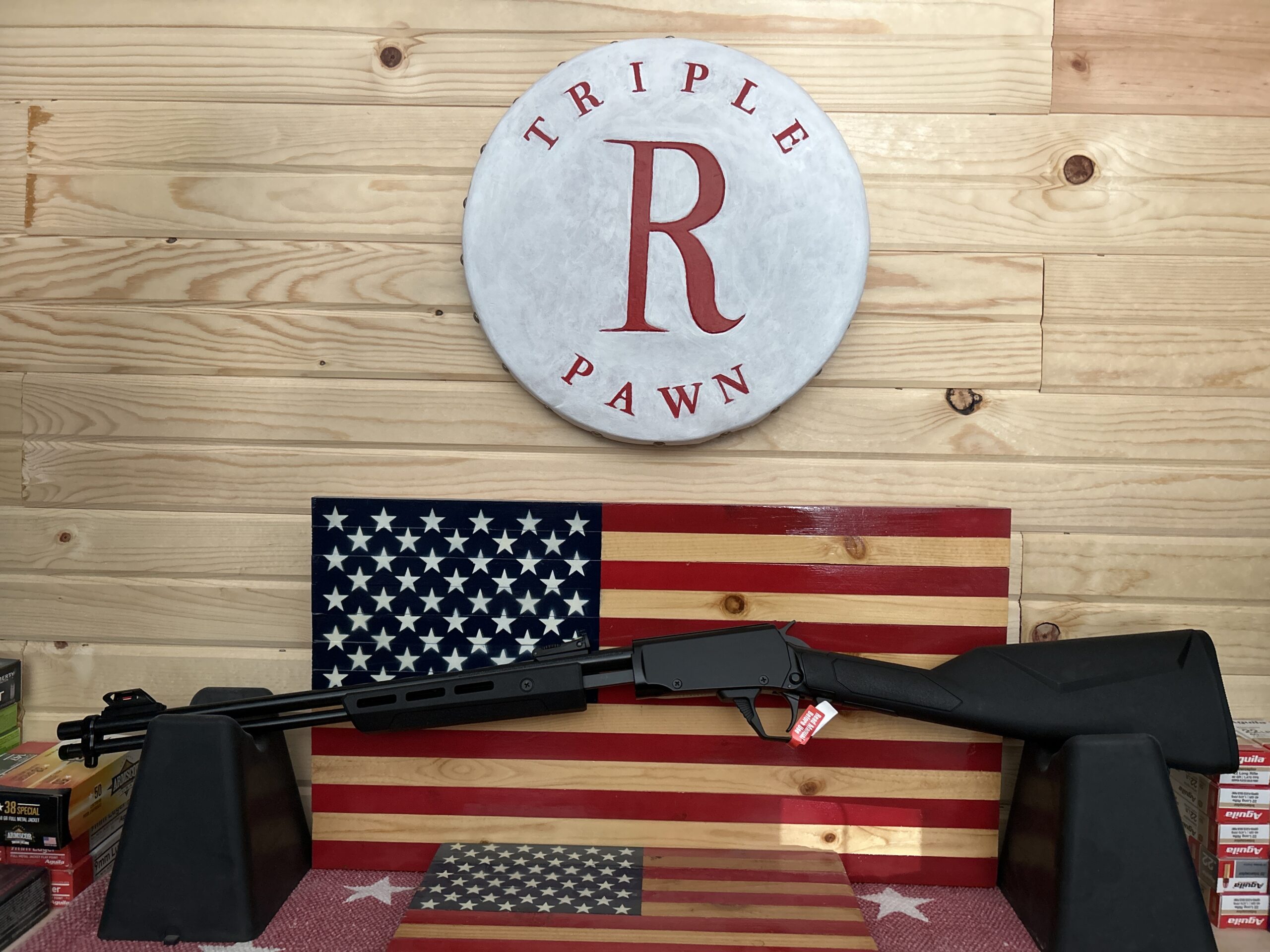 Hunting rifle displayed on American flag background.