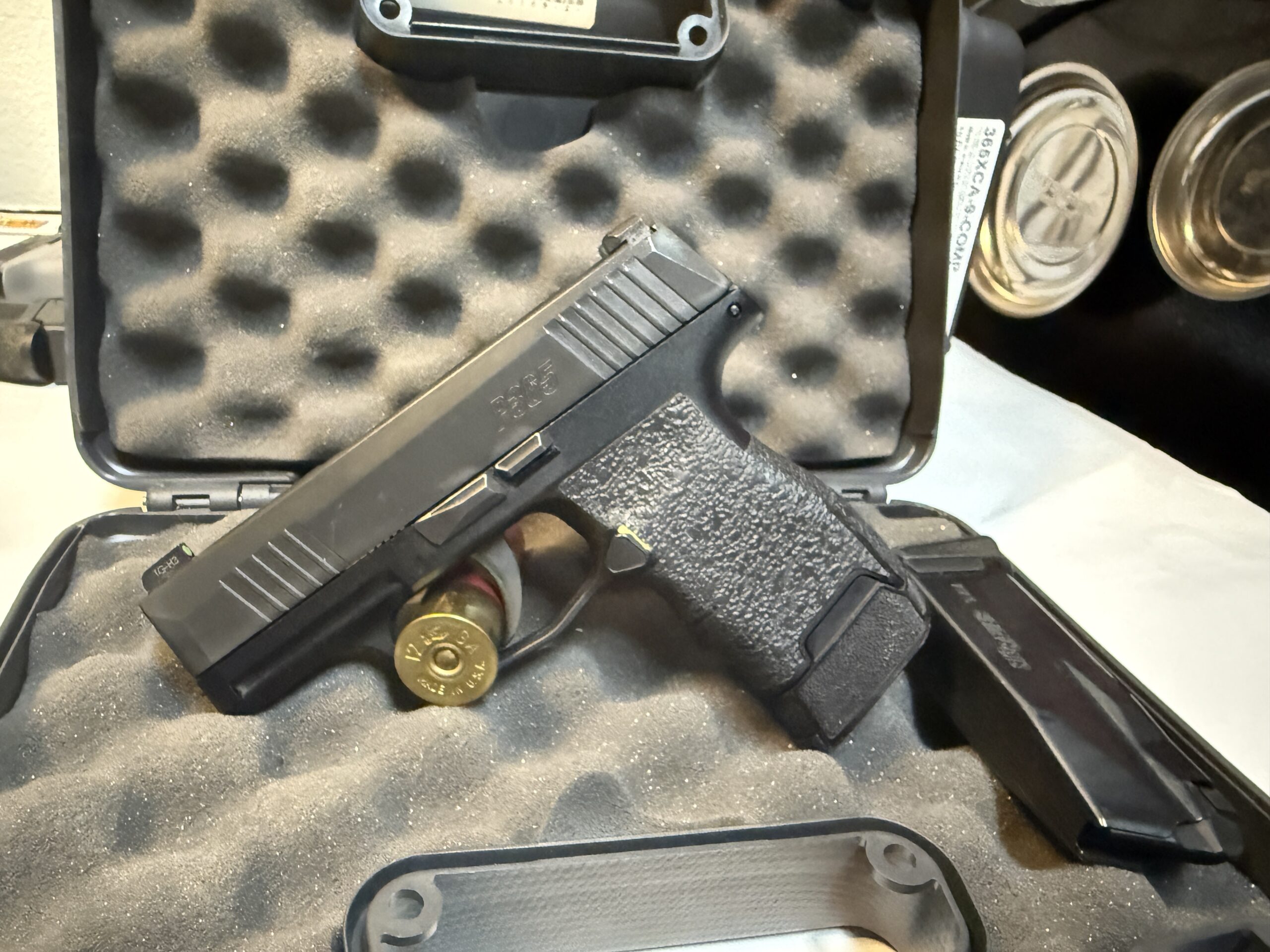 Handgun in foam case with ammunition visible.