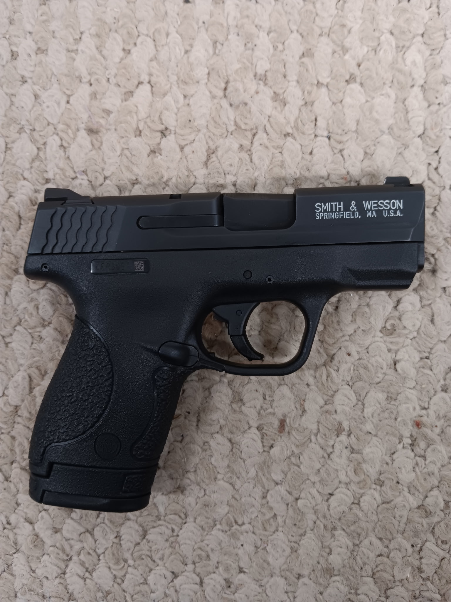 Black Smith & Wesson handgun on carpet