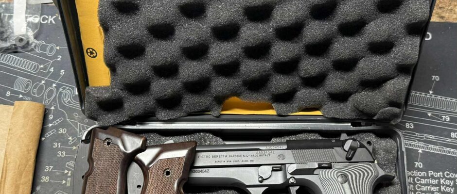 Handgun with wooden grips and magazines in a case.