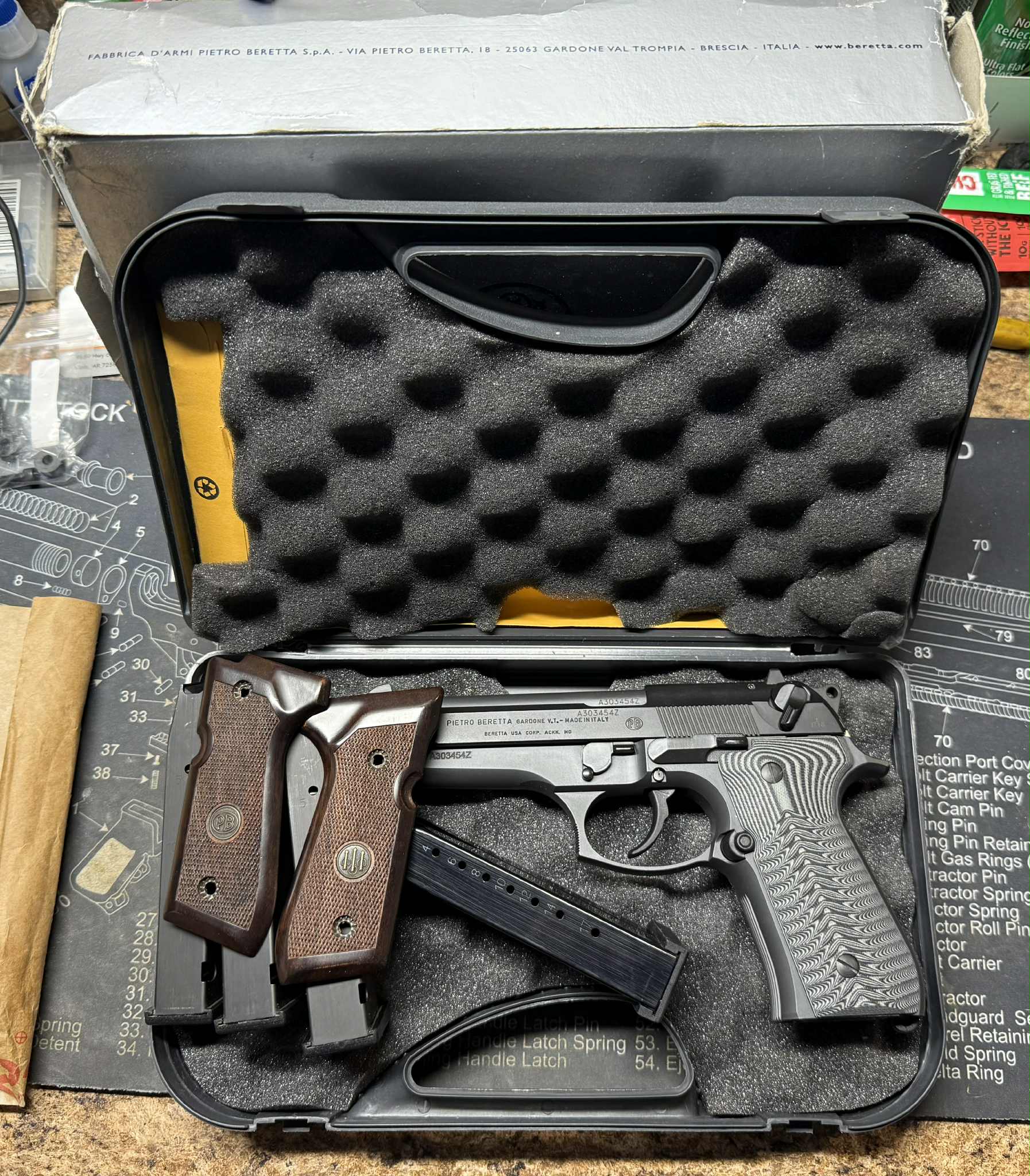 Handgun with wooden grips and magazines in a case.