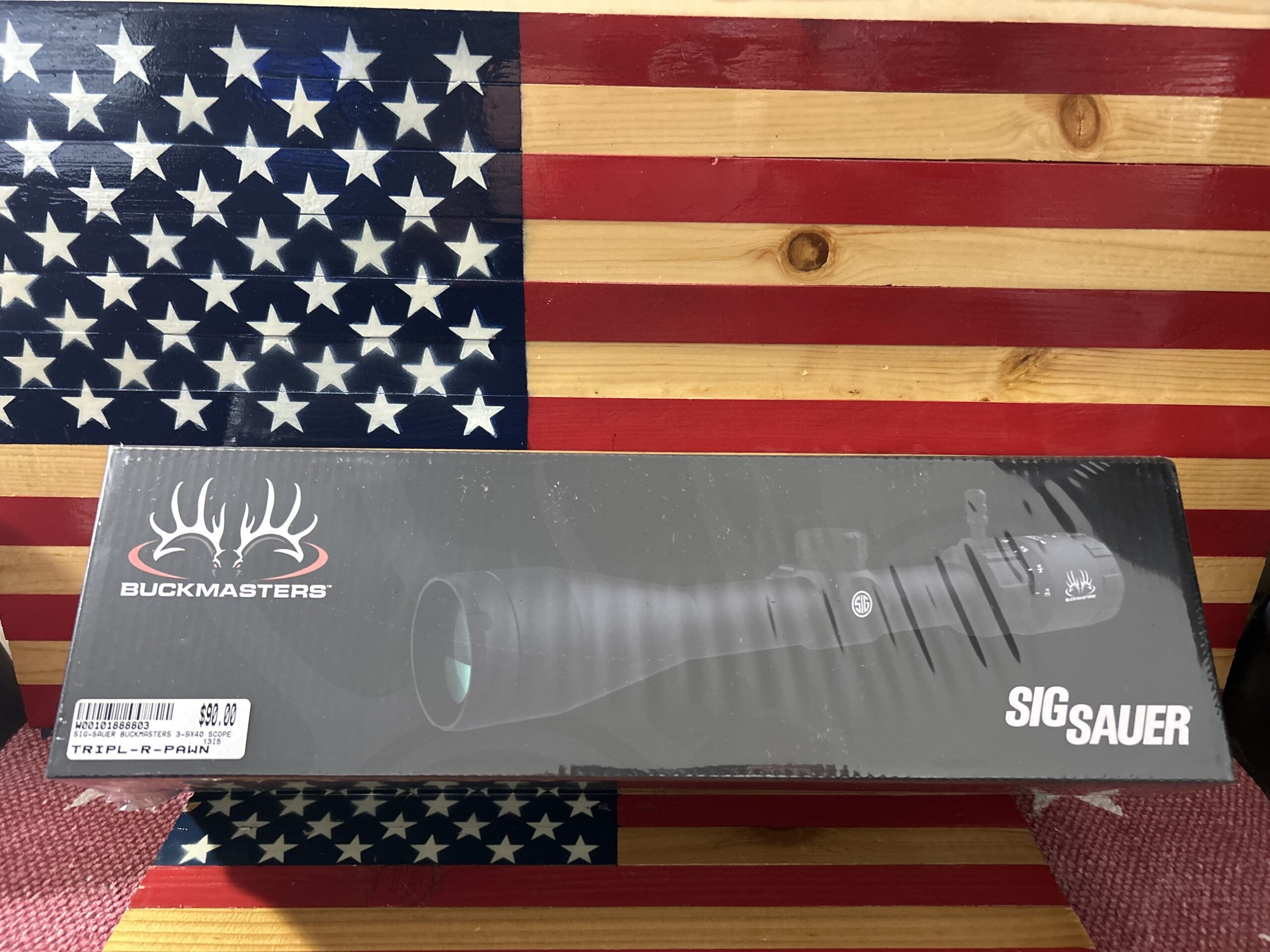 Buckmasters Sig Sauer scope against American flag.