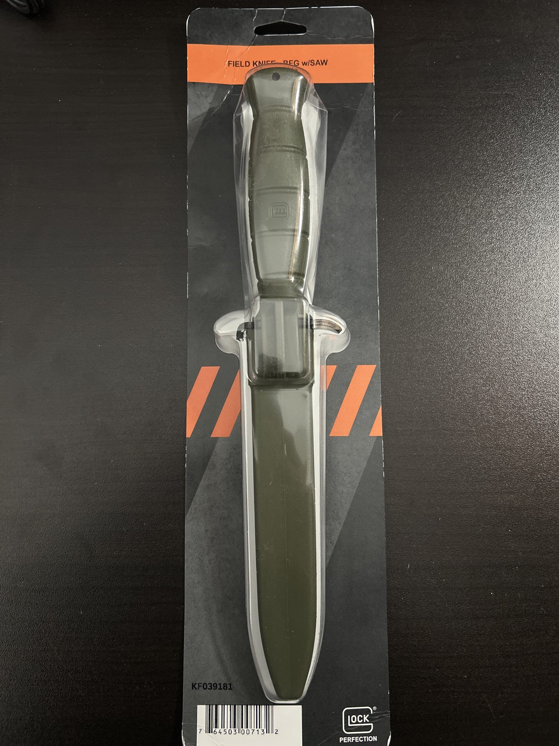 Green field knife with saw in package.