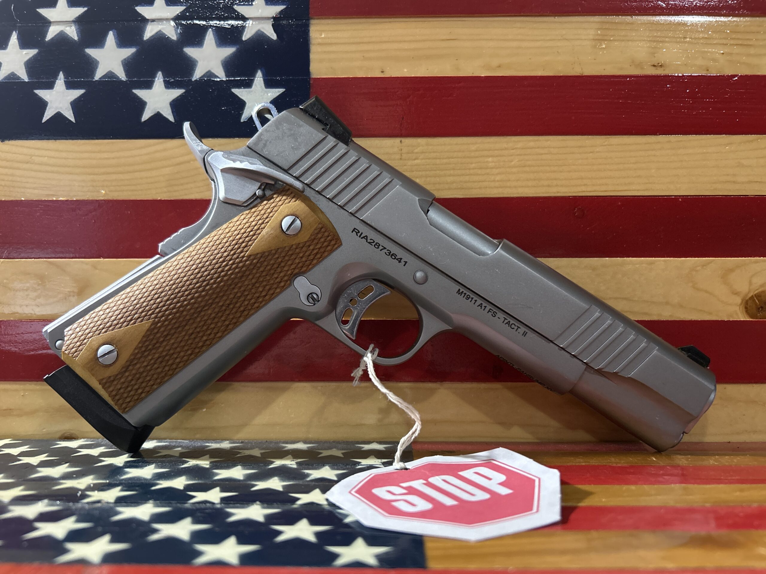 Handgun on American flag background with stop sign.